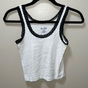 brandy Melville tank top with black lace stitched around the neck and arms.